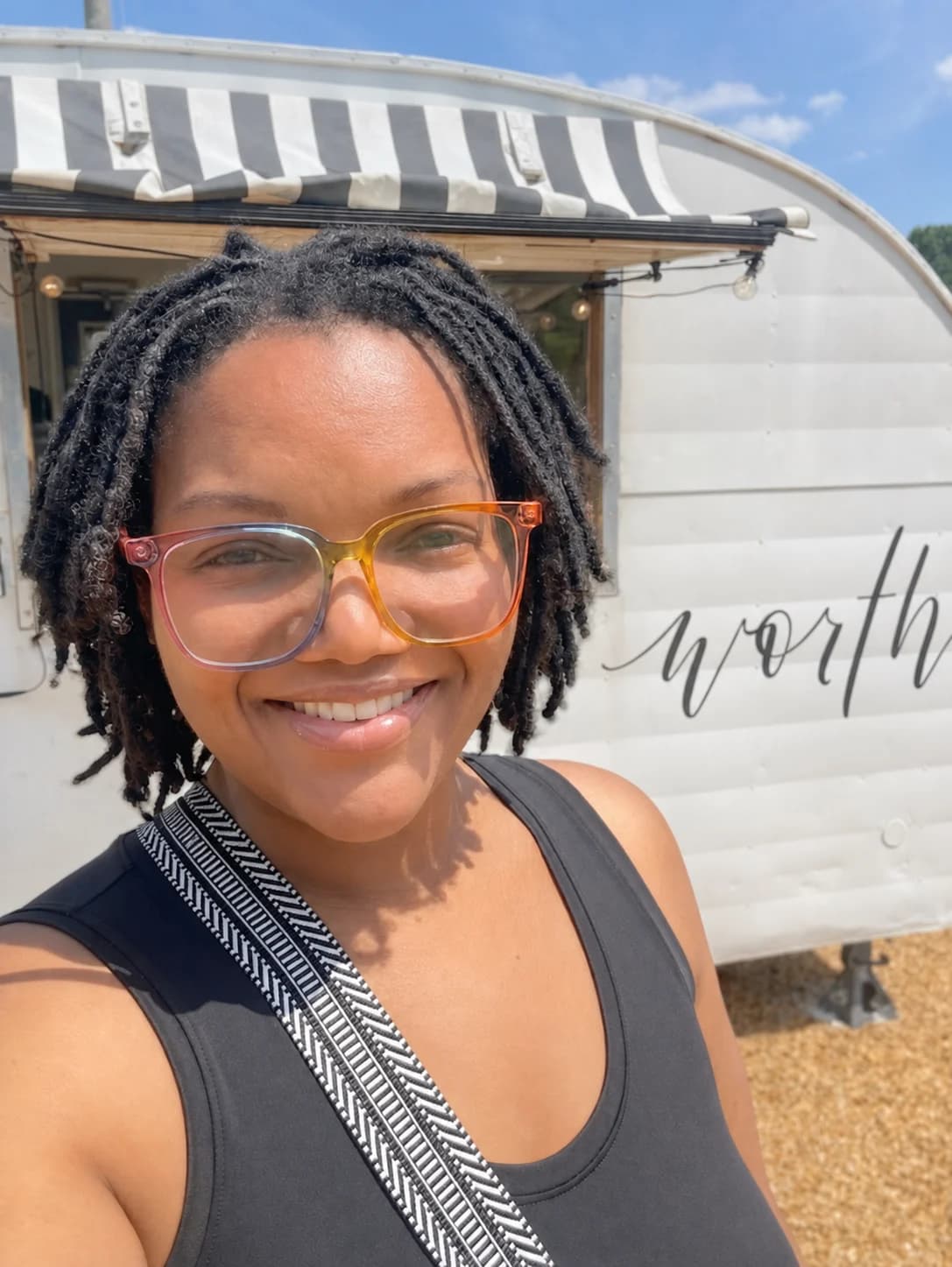 Makeda Boehm smiling in front of a trailer marked worth